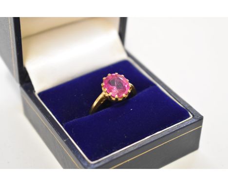A claw set oval ruby unmarked yellow metal ring, 4.3g total weight. 