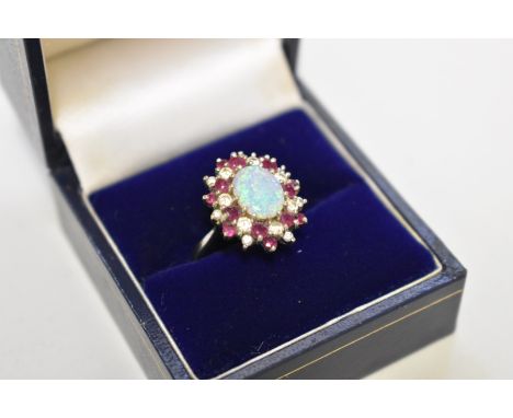 An opal, diamond and ruby white gold ring, stamped 18ct, 52g total weight. 