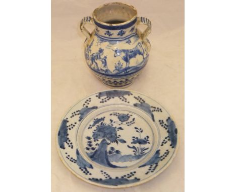 An 18th Century Delft plate decorated in underglaze blue with stylised flowers and rocks, together with a 19th Century Contin
