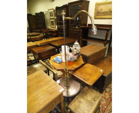 A brass adjustable standard lamp with central circular mahogany table section on a circular foot