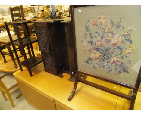 A needlework firescreen in mahogany frame, a carved oak wall unit, an oak three tier table and a rush seat ladder back chair