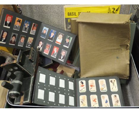 A suitcase containing an assortment of various vintage cigarette cards in albums, a hardback copy of "60 Years a Queen", vari