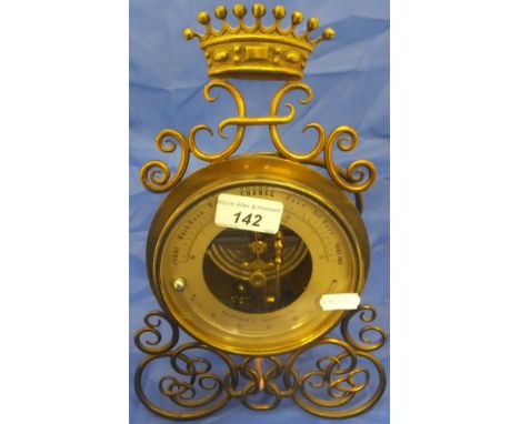 An Edwardian Fahrenheit thermometer in brass case with built in barometer, the back marked "PHBN", on a scrollwork brass ease