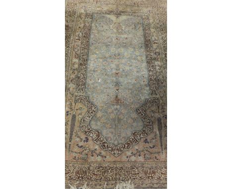 A Persian prayer rug, the central silver ground with vase and scrolling floral and foliate decoration in salmon, cream and ci