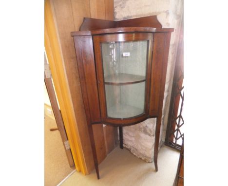 An Edwardian mahogany and inlaid and transfer decorated corner cupboard, the galleried top above a single shaped and glazed d