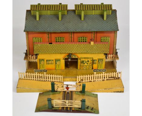 Hornby 0 gauge tinplate engine shed together with Windsor station platform and level crossing.
