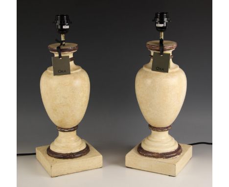 A pair of Oka 'Gela' wooden table lamps, of vase form, painted in ivory shades with brown detail, upon integral plinth bases,