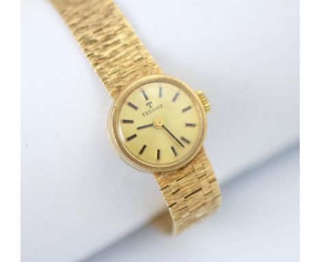 A yellow metal Tissot ladies wristwatch, the circular gold coloured dial with baton markers, set to a plain polished case and
