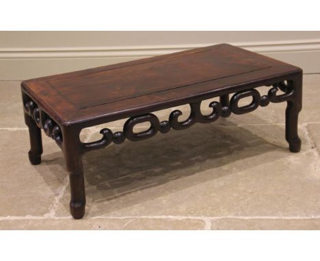 A Chinese rosewood opium table, the cleated rectangular top, with an openwork 'link' frieze, upon cylindrical supports and pa