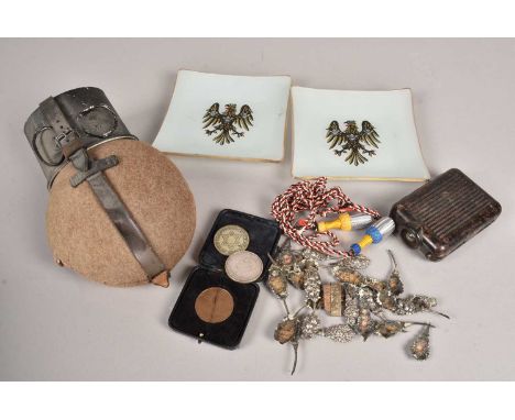 An assortment of German items, including a water flask, an NSDAP medallion and two others, a Third Reich pocket light, a knot