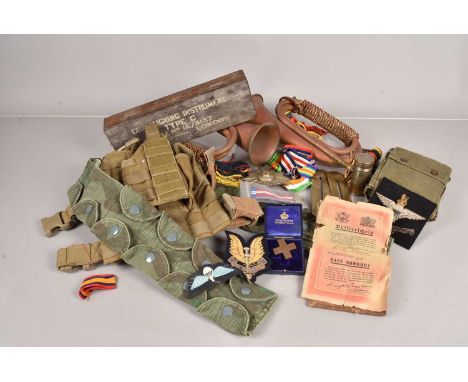 An assortment of various items, including two Bugles, a selection of medal ribbons, Russian badges, a German Air Drop Leaflet