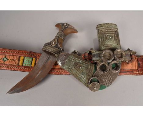 A Middle Eastern Clad Jambiya, having horn handle with applied white metal decoration, white metal decorated scabbard with ri