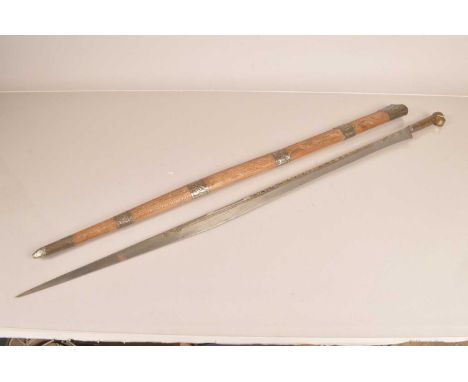 A North African Flyssa sword, having swollen back edge to a 90cm long, engraved and gilt design, with engraved brass hilt, co