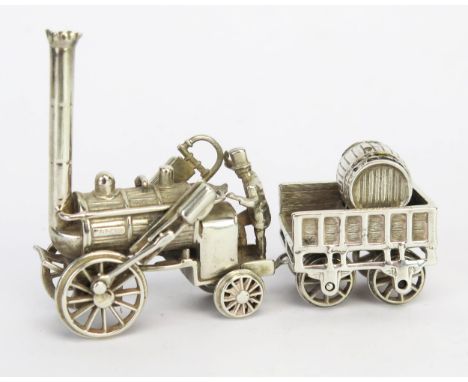 A 20th century silver model of Stephenson's "Rocket", with tender and figure, stamped 925, overall length 8,5cm, 99gms, 3.18o