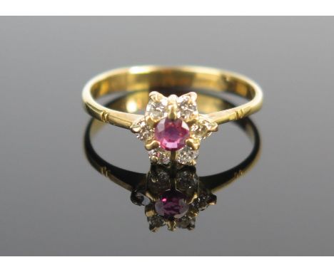 An 18ct Gold, Ruby and Diamond Cluster Ring, 8mm head, c. 3.2mm ruby, size L.25, 1.7g 