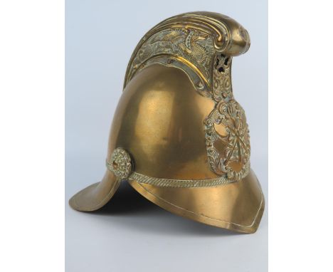 An all brass fireman's helmet, with dragon decorated comb, crossed axes and flaming torch badge, leather liner. 