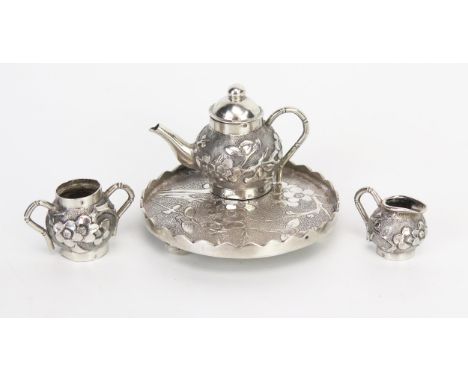 A Chinese silver miniature tea service and tray, with prunus decoration, total weight of silver 49gms,  1.59ozs 