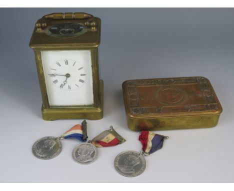 A WWI 1914 Christmas Tin, three commemorative medallions and carriage clock (running)