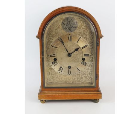 A mahogany mantel clock of arched outline with silvered arched Roman dial, the HALLER triple train movement striking to gongs