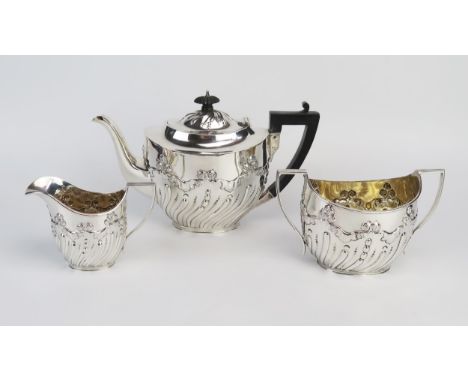 A Victorian silver three-piece tea service, maker James Deakin &amp; Sons, Sheffield, 1897, of oval outline with floral and w