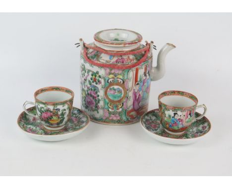 A Cantonese Famille Verte teapot and cover, together with two matching cups and saucers. (5). 