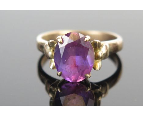 A 14K Gold and Purple Stone Dress Ring, 10x8mm stone, size J.75, 3.3g. Possibly purple topaz. 