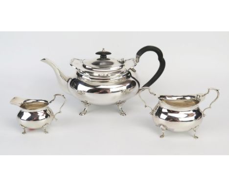 A matched silver three-piece tea service, of barge-shaped outline, with wavy edge border, raised on swept legs, total weight 