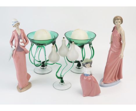 Three Nao porcelain figurines, a pair of clear and green glass candle holders and a clear and green glass three-branch oil la
