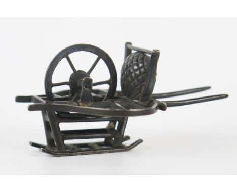 A Chinese silver model of a cart, maker Wang Hing, with single spoked wheel, 6.5cm long, 23gms, 0.74ozs 