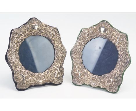 A pair of Elizabeth II silver easel photograph frames, maker S S, London, 1983, with embossed putti and scroll, decoration, 1