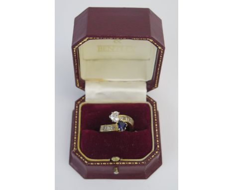 A Modern 18ct Gold, Sapphire and Diamond 'Entwined Hearts' Crossover Ring, the primary stones c. 6.3x5mm and with baguette cu