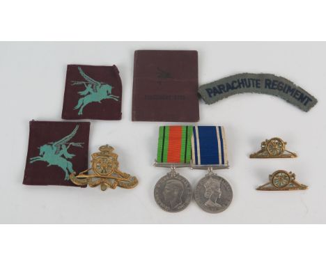 A Parachute Regiment cloth shoulder patch, two Pegasus cloth flashes, Royal Artillery cap badge, and a pair of medals, Defenc