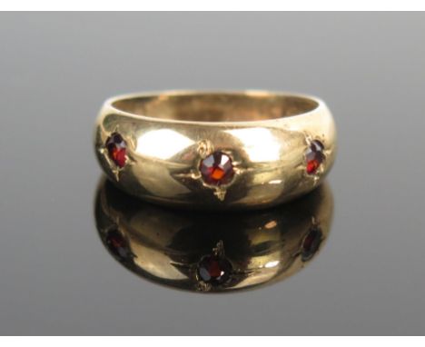 A 9ct Gold and Garnet Three Stone Gypsy Ring, size M.75, 2.3g 