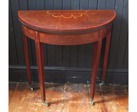 A 19th century mahogany crossbanded and inlaid demi-lune card table, the hinged top with inlaid garland decoration enclosing 