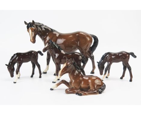 A Beswick model of a mare, with a lying foal, together with three Royal Doulton foals. (5)