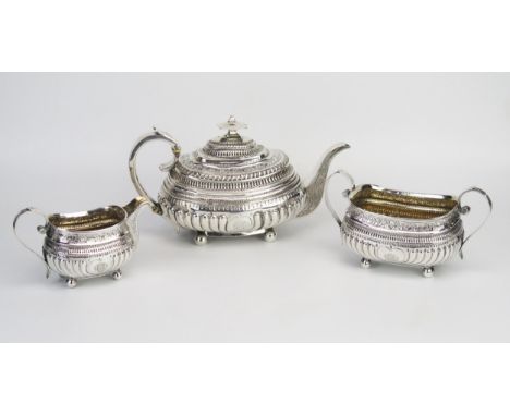 A George III matched silver three-piece tea service, the teapot, maker Charles Fox I, London, 1814, monogrammed, of barge-sha