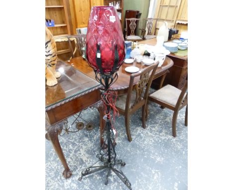 AN UNUSUAL WROUGHT IRON STANDARD LAMP WITH CRANBERRY SHADE. 