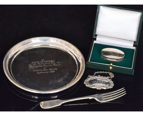 Four items of silver, a cased pill box, a decanter label, a fiddle pattern dessert fork and a small circular salver, various 