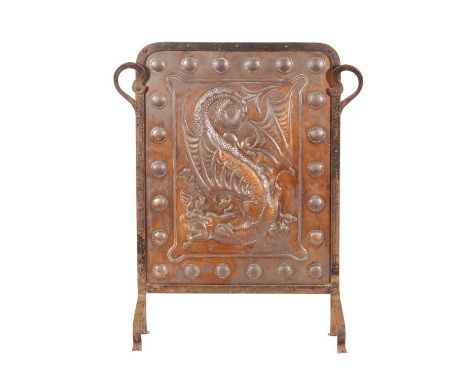 An Arts and Crafts embossed iron framed copper firescreen, the panel decorated with a fire breathing dragon with a beaded loz