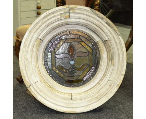 A late 19th Century coloured leaded light stained glass bulls eye window, with floral design and painted stepped moulded fram