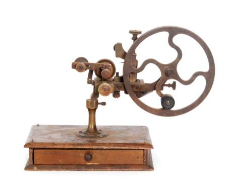 A 19th Century watch maker's lathe, large four spoked handcrank wheel on a mahogany base fitted with a drawer and tools, A/F.