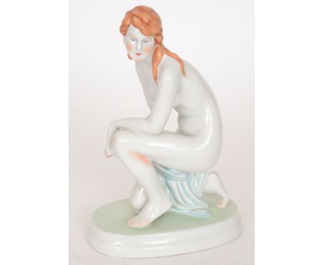 A Zsolnay Pecs figurine modelled as a crouching nude draped in a blue scarf with long brown hair, printed marks, height 23cm