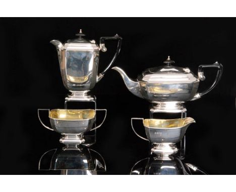 A hallmarked silver four piece boat shaped pedestal tea set of plain form each piece terminating in angular scroll handle, to