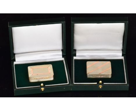 Two boxed hallmarked silver and gold pill boxes each with engine turned decoration and gold band decoration to hinged covers,