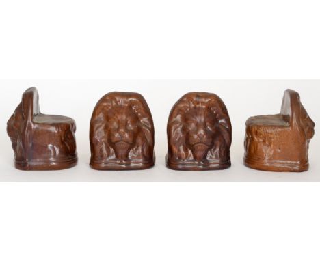Four late 19th Century stoneware sash window stops modelled as lions heads, height 13cm. (4)