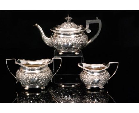 A late Victorian hallmarked silver bachelors tea set comprising of tea pot, sugar bowl and cream jug, each with all over embo