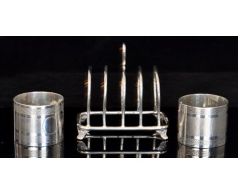 A hallmarked silver four division toast rack of plain form with loop handle, on four paw feet, Sheffield 1936, Viners Ltd, to
