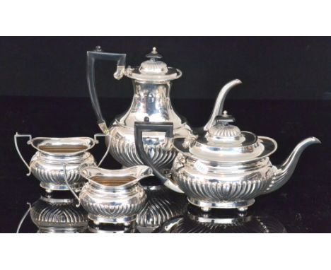 A hallmarked silver four piece boat shaped tea set each with part fluted decoration below gadroon borders and raised on four 