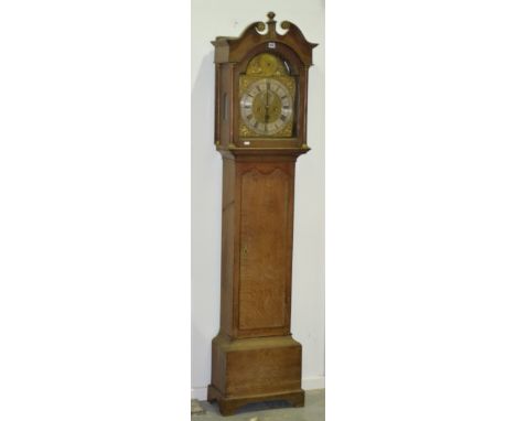 A 19th Century oak long case clock, with an arched brass dial with silvered chapter ring and eight day striking movement encl