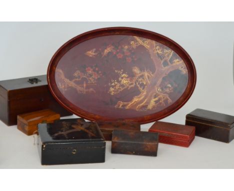 An early 20th Century cinnibar carved cigarette box together with various wooden and leather boxes, a lacquer oval serving tr